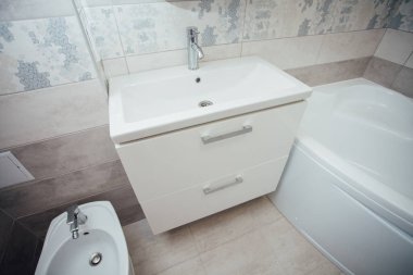 Modern bathroom wash basin with chrome faucet and gray tiling