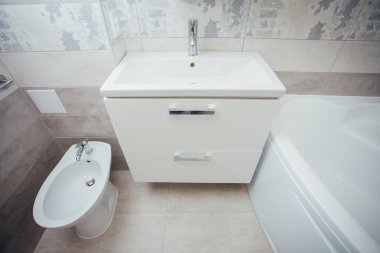 Modern bathroom wash basin with chrome faucet and gray tiling