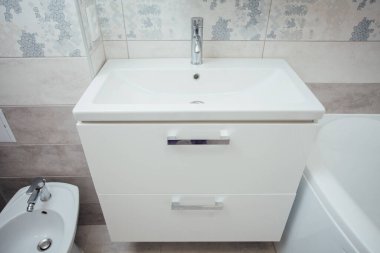 Modern bathroom wash basin with chrome faucet and gray tiling