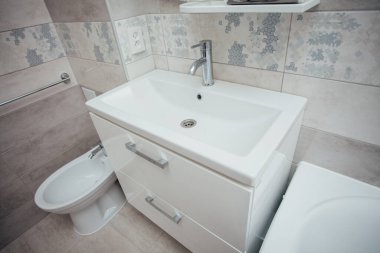 Modern bathroom wash basin with chrome faucet and gray tiling