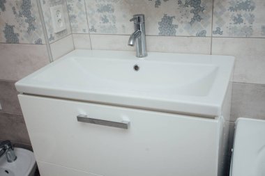 Modern bathroom wash basin with chrome faucet and gray tiling