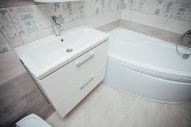 Modern banyo lavabosu krom musluk ve gri fayansla