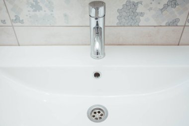 Modern banyo lavabosu krom musluk ve gri fayansla