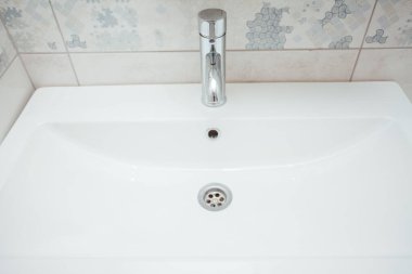 Modern banyo lavabosu krom musluk ve gri fayansla