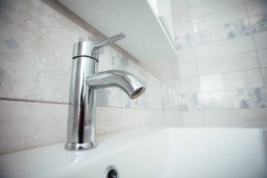 Modern banyo lavabosu krom musluk ve gri fayansla