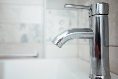 Modern banyo lavabosu krom musluk ve gri fayansla