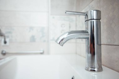 Modern banyo lavabosu krom musluk ve gri fayansla