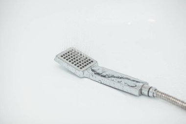 Beyaz zemin üzerinde su akan gümüş el banyosu