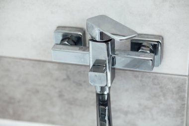 Modern banyo lavabosu krom musluk ve gri fayansla