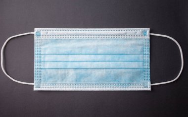 Gri arkaplanda tek kullanımlık yüz maskesi