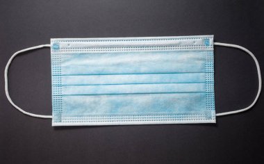 Gri arkaplanda tek kullanımlık yüz maskesi