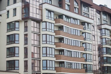 Güneşli bir günde gökyüzü olan modern bir apartman. Modern bir apartmanın cephesi