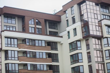 Güneşli bir günde gökyüzü olan modern bir apartman. Modern bir apartmanın cephesi
