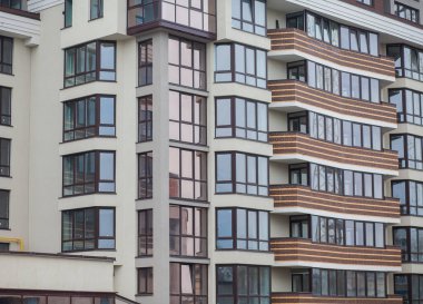 Güneşli bir günde gökyüzü olan modern bir apartman. Modern bir apartmanın cephesi