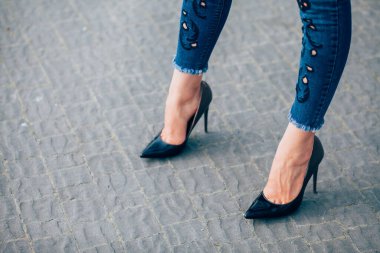 Siyah topuklu bir kadın. Yüksek topuklu kadın bacaklarının yakınlaşması