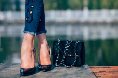 Siyah topuklu bir kadın. Yüksek topuklu kadın bacaklarının yakınlaşması