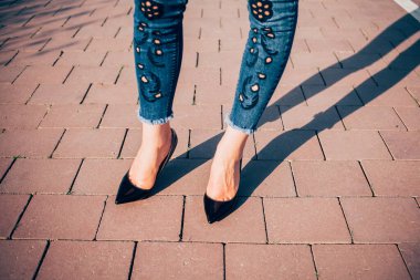 Siyah topuklu bir kadın. Yüksek topuklu kadın bacaklarının yakınlaşması