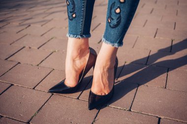 Siyah topuklu bir kadın. Yüksek topuklu kadın bacaklarının yakınlaşması