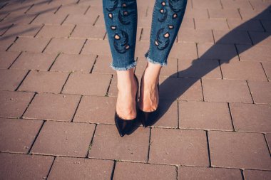 Siyah topuklu bir kadın. Yüksek topuklu kadın bacaklarının yakınlaşması