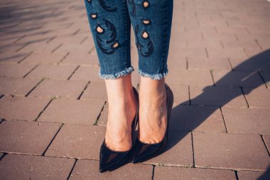 Siyah topuklu bir kadın. Yüksek topuklu kadın bacaklarının yakınlaşması