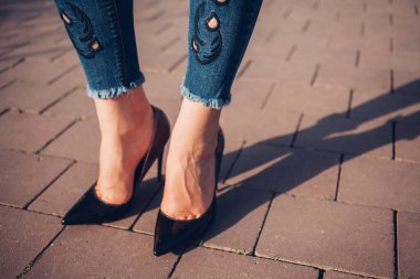 Siyah topuklu bir kadın. Yüksek topuklu kadın bacaklarının yakınlaşması