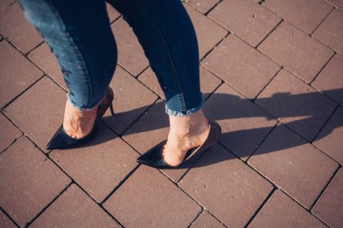 Siyah topuklu bir kadın. Yüksek topuklu kadın bacaklarının yakınlaşması