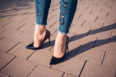 Siyah topuklu bir kadın. Yüksek topuklu kadın bacaklarının yakınlaşması