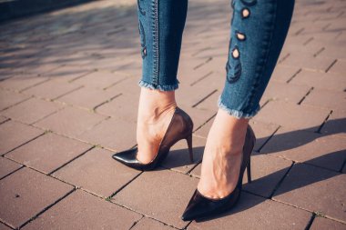 Siyah topuklu bir kadın. Yüksek topuklu kadın bacaklarının yakınlaşması