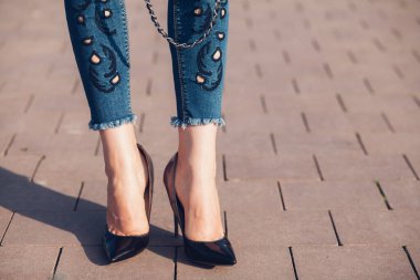 Siyah topuklu bir kadın. Yüksek topuklu kadın bacaklarının yakınlaşması