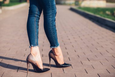 Siyah topuklu bir kadın. Yüksek topuklu kadın bacaklarının yakınlaşması
