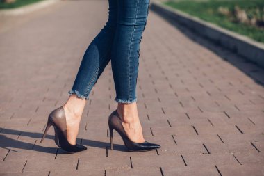 Siyah topuklu bir kadın. Yüksek topuklu kadın bacaklarının yakınlaşması