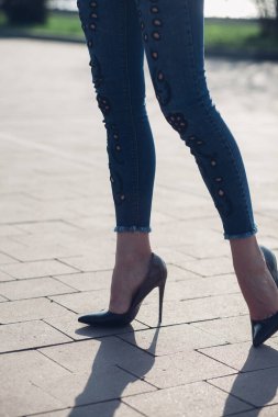 Siyah topuklu bir kadın. Yüksek topuklu kadın bacaklarının yakınlaşması