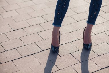 Siyah topuklu bir kadın. Yüksek topuklu kadın bacaklarının yakınlaşması