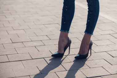 Siyah topuklu bir kadın. Yüksek topuklu kadın bacaklarının yakınlaşması