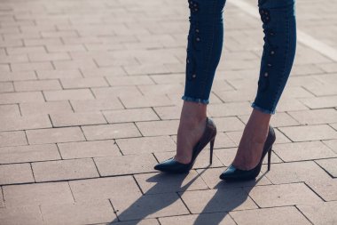 Siyah topuklu bir kadın. Yüksek topuklu kadın bacaklarının yakınlaşması