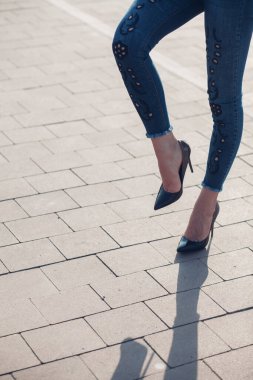 Siyah topuklu bir kadın. Yüksek topuklu kadın bacaklarının yakınlaşması