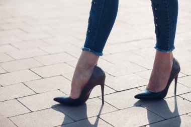 Siyah topuklu bir kadın. Yüksek topuklu kadın bacaklarının yakınlaşması