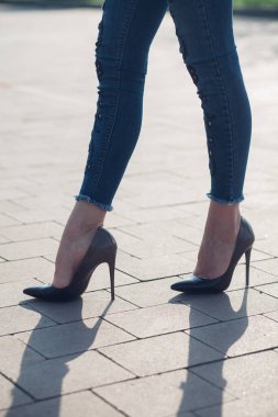 Siyah topuklu bir kadın. Yüksek topuklu kadın bacaklarının yakınlaşması