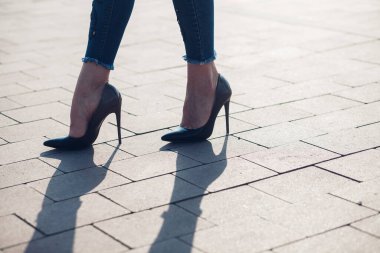 Siyah topuklu bir kadın. Yüksek topuklu kadın bacaklarının yakınlaşması