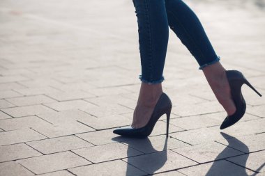 Siyah topuklu bir kadın. Yüksek topuklu kadın bacaklarının yakınlaşması