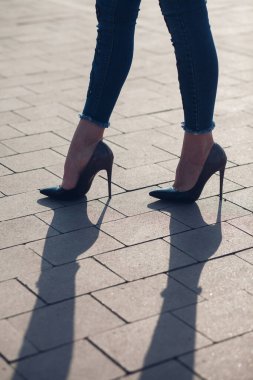Siyah topuklu bir kadın. Yüksek topuklu kadın bacaklarının yakınlaşması