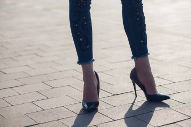 Siyah topuklu bir kadın. Yüksek topuklu kadın bacaklarının yakınlaşması