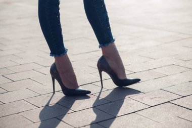 Siyah topuklu bir kadın. Yüksek topuklu kadın bacaklarının yakınlaşması