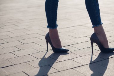 Siyah topuklu bir kadın. Yüksek topuklu kadın bacaklarının yakınlaşması