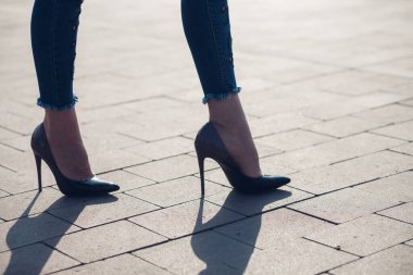 Siyah topuklu bir kadın. Yüksek topuklu kadın bacaklarının yakınlaşması