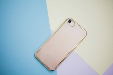Renkli arkaplanda fotokopi alanı olan akıllı telefon. Modern ve minimal biçim rengi