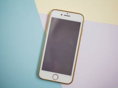 Renkli arkaplanda fotokopi alanı olan akıllı telefon. Modern ve minimal biçim rengi