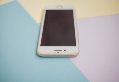 Renkli arkaplanda fotokopi alanı olan akıllı telefon. Modern ve minimal biçim rengi