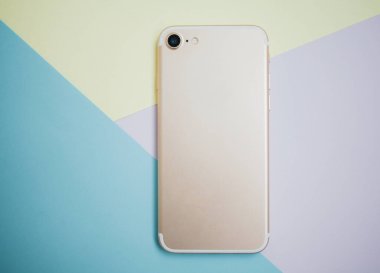 Renkli arkaplanda fotokopi alanı olan akıllı telefon. Modern ve minimal biçim rengi