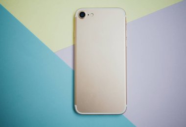 Renkli arkaplanda fotokopi alanı olan akıllı telefon. Modern ve minimal biçim rengi